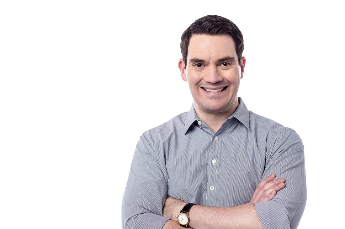 Picture of man in dress shirt arms folded smiling
